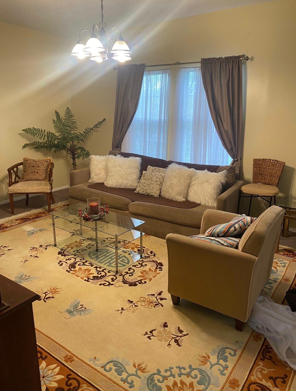 Shared living room with sofas, chairs, coffee table, and windows